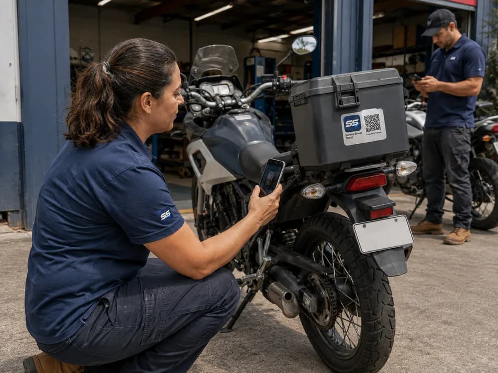 Illustrative scene of a technician scanning a Service Sheet QR label on a parked motorcycle at a workshop.